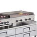 A large stainless steel Wells countertop griddle with meat on it.