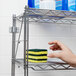 A hand holding a sponge on a Metro Erecta chrome wire shelf.