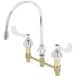 A chrome T&amp;S deck mount faucet with two wrist action handles and a gooseneck spout.