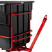A black Rubbermaid tilt truck with red wheels.