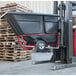 A black Rubbermaid tilt truck container on a forklift.