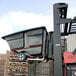 A black Rubbermaid forkliftable tilt truck filled with trash on a forklift.