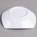 A white Carlisle melamine bowl on a gray surface.