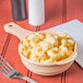 A tan GET SuperMel bowl with macaroni and cheese in it, with a fork next to it.