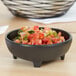 A Carlisle melamine molcajete ramekin filled with salsa on a table.