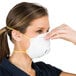 A woman wearing a Cordova N-95 valved particulate respirator.
