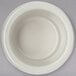 A Carlisle bone white plastic ramekin on a gray background.