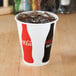 A Solo paper cup with a Coke and ice in it.