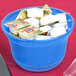 A Tablecraft cobalt blue cast aluminum bowl filled with white yogurt packets.