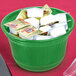 A green Tablecraft metal bowl filled with candy on a hotel buffet counter.