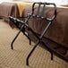 A black metal CSL folding luggage rack with black straps.