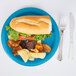 A turquoise blue Creative Converting paper plate with a sandwich and potato chips.