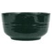 A black Tablecraft cast aluminum fruit bowl with a speckled surface and a green rim.