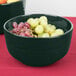 A Tablecraft hunter green and white speckled fruit bowl filled with grapes on a table.