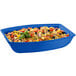 A cobalt blue rectangular cast aluminum bowl with food in it.