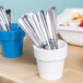 A white Tablecraft round condiment bowl filled with silverware.