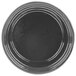 A natural cast aluminum souffle bowl on a black plate with a rim.