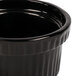 A black cast aluminum Tablecraft souffle bowl with ridges on the outside.
