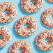 A close up of a group of donuts with Adourne Rainbow Sprinkles on top.