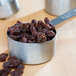 A measuring cup full of Regal California Select Raisins on a table.