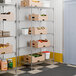 A chrome wire shelving unit with five adjustable shelves, holding various boxes and containers.