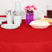 A table with a Classic Red OctyRound table cover and plates and cups on it.