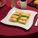 A Fineline bone plastic square plate with food on it.