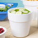 A white Tablecraft round condiment bowl filled with cucumbers.