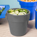 A Tablecraft round granite condiment bowl filled with cucumbers on a table in a salad bar.