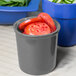 A Tablecraft granite condiment bowl filled with sliced tomatoes on a counter.