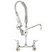 A T&S chrome wall mounted pre-rinse faucet with a hose attached.