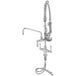 A close-up of a chrome T&S pre-rinse faucet with hoses.