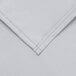 A close up of a gray rectangular cloth table cover with a hemmed edge.
