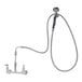 A T&S white wall mount faucet with a hose and angled spray valve.