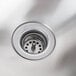 A close-up of a stainless steel wall mount hand sink with a basket drain.