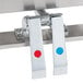 A close-up of a pair of white plastic handles with red and blue circles