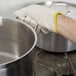A person wearing a Cordova seamless loop in terry glove holding a pot.
