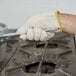 A person wearing Cordova seamless loop in terry gloves using a tool.
