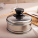 A silver stainless steel Town Dim Sum Steamer Cover on a table.