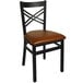 A black metal BFM Seating restaurant chair with a light brown vinyl seat.