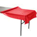 A table with a red Creative Converting plastic tablecloth.