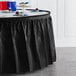 A table with a black velvet plastic table skirt on it.