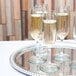 A tray with several Libbey Bristol Valley flute glasses of champagne on it.