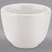 A Tuxton white china sake tea cup on a gray surface.