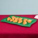 A green Tablecraft rectangular platter with croissants on it.