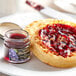 A plate with a waffle topped with Dickinson's Pure Concord Grape Jam.