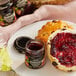 A plate with jam and bread next to a jar of Dickinson's Pure Cascade Mountain Red Raspberry Preserves.