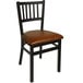 A BFM Seating black steel side chair with a light brown vinyl seat.