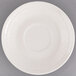 An ivory china saucer with an embossed spiral design on the rim.