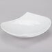 A CAC bone white porcelain peach plate with a curved edge.